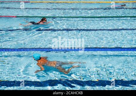 Schwimmer genießen den Pool im Woodgreen Leisure Centre, Oxfordshire, wenn das warme Wetter anhält. Stockfoto