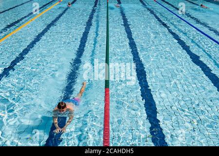 Schwimmer genießen den Pool im Woodgreen Leisure Centre, Oxfordshire, wenn das warme Wetter anhält. Stockfoto