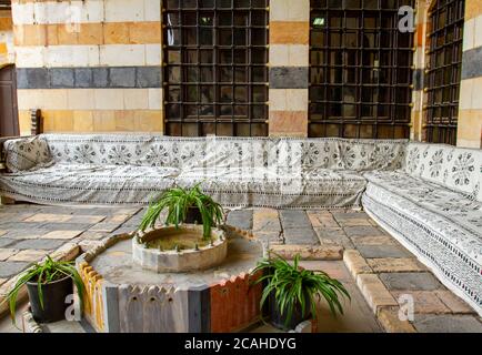 Damaskus, Syrien 03/28/2010: Eine Sitzgruppe im Innenhof des Azm-Palastes mit einem künstlerischen alten Stil Diwan (arabisches Sofa) als Eckeinheit und Co Stockfoto