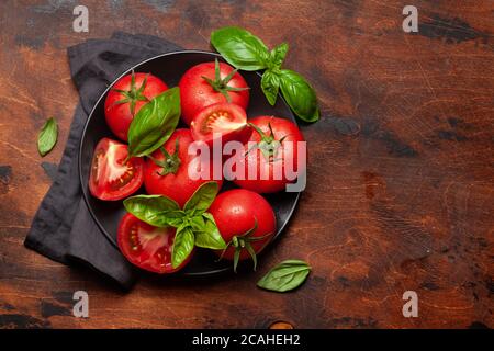 Zutaten der italienischen Küche. Frische Gartentomaten und Basilikumkräuter. Draufsicht mit Kopierbereich. Flach liegend Stockfoto