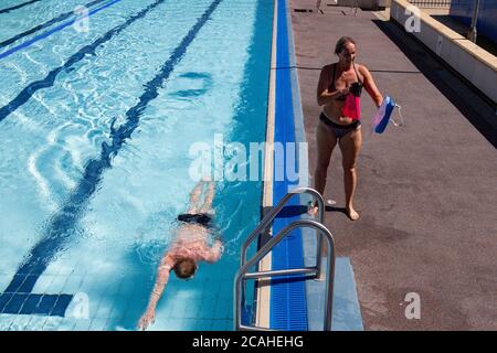 Schwimmer genießen den Pool im Woodgreen Leisure Centre, Oxfordshire, wenn das warme Wetter anhält. Stockfoto