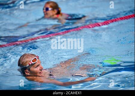 Schwimmer genießen den Pool im Woodgreen Leisure Centre, Oxfordshire, wenn das warme Wetter anhält. Stockfoto