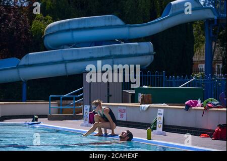 Schwimmer genießen den Pool im Woodgreen Leisure Centre, Oxfordshire, wenn das warme Wetter anhält. Stockfoto