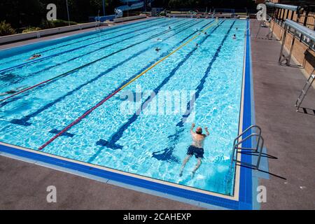 Schwimmer genießen den Pool im Woodgreen Leisure Centre, Oxfordshire, wenn das warme Wetter anhält. Stockfoto