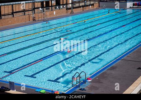 Schwimmer genießen den Pool im Woodgreen Leisure Centre, Oxfordshire, wenn das warme Wetter anhält. Stockfoto