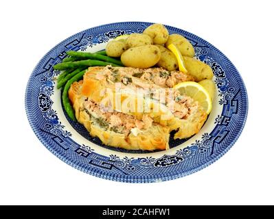 In Scheiben geschnittenes Blätterteig überzogene Lachs-Wellington-Mahlzeit mit neuen Kartoffeln Und Spargel isoliert auf weißem Hintergrund Stockfoto