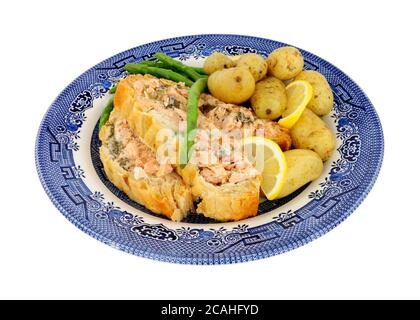 In Scheiben geschnittenes Blätterteig überzogene Lachs-Wellington-Mahlzeit mit neuen Kartoffeln Und Spargel isoliert auf weißem Hintergrund Stockfoto