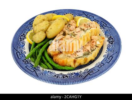 In Scheiben geschnittenes Blätterteig überzogene Lachs-Wellington-Mahlzeit mit neuen Kartoffeln Und Spargel isoliert auf weißem Hintergrund Stockfoto