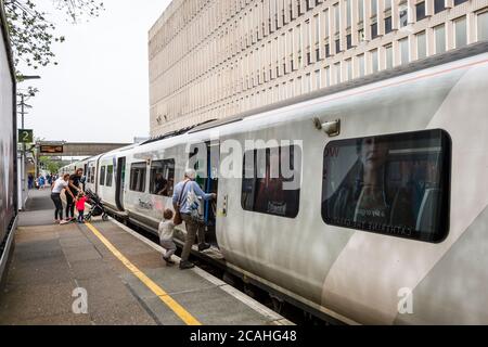 Passagiere, die einen Zug der Klasse 700 in der Thameslink-Lackierung am Bahnhof Crawley, West Sussex, England, besteigen. Stockfoto