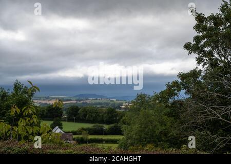 Stürmischer Himmel über Fileds von einem Hügel in Großbritannien aus gesehen. Stockfoto