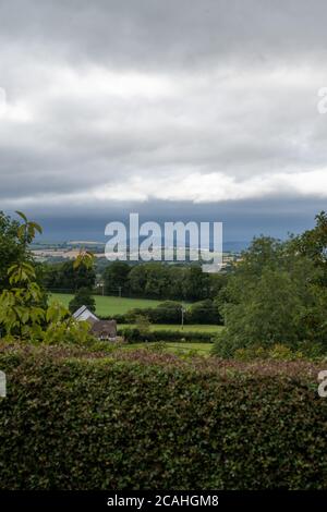 Stürmischer Himmel über Fileds von einem Hügel in Großbritannien aus gesehen. Stockfoto