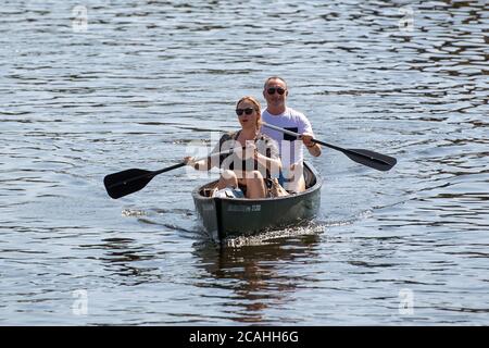 Die Leute Kanu entlang des Flusses Bure in Wroxham auf den Norfolk Broads, wie das warme Wetter weiter. Stockfoto