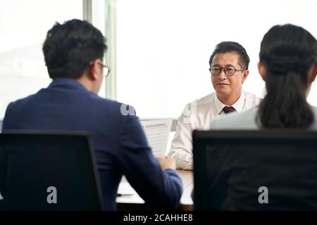 Ältere asiatische Business Mann Job Sucher wird von jungen Personalchefs interviewt Stockfoto