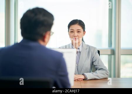 Junge asiatische Geschäftsfrau auf der Suche nach Job wird von Human Resources Manager interviewt