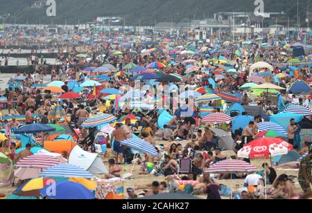 Die Menschen genießen das heiße Wetter am Bournemouth Strand in Dorset. Stockfoto