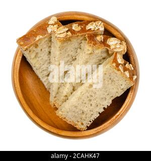 Scheiben Dinkelbrot in einer Holzschüssel. Braunes Sauerteigbrot, eine Mischung aus Dinkelmehl, Sauerteig, Sonnenblumenkernen und Gewürzen, im Ofen gebacken. Grundnahrungsmittel Stockfoto