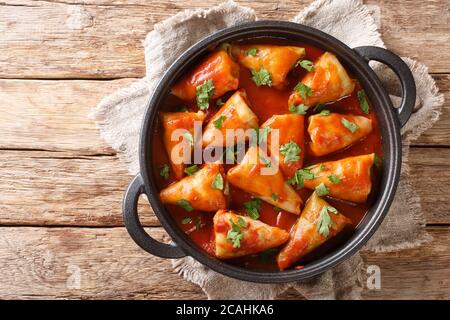 Kohlröllchen gefüllt mit Hackfleisch und Reis und gebacken mit einer heißen Tomatensauce close-up in einer Schüssel auf dem Tisch. Horizontale Draufsicht von oben Stockfoto