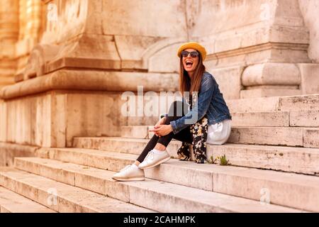 Eine wunderschöne Frau sitzt auf der Treppe eines Bürgermeisters Europäische Wahrzeichen. Stockfoto