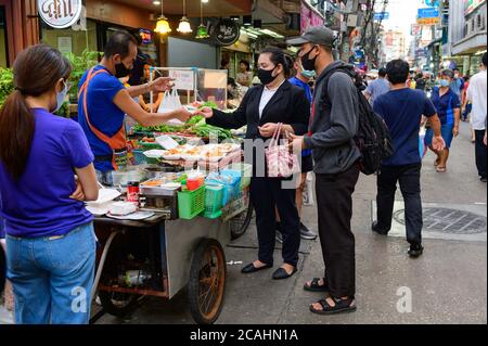 Nicht identifizierter Straßenhändler verkaufen Lebensmittel in einer Schaumstoffkiste für Kunden Stockfoto