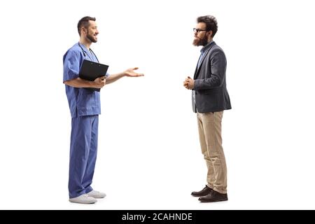 In voller Länge Profilaufnahme eines Mediziners, der mit Händen erklärt und gestikiert und mit einem bärtigen Mann auf weißem Hintergrund steht Stockfoto