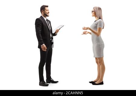 In voller Länge Profilaufnahme einer jungen Frau im Gespräch mit einem Mann in schwarzem Anzug mit Cliboard in den Händen isoliert auf weißem Hintergrund Stockfoto