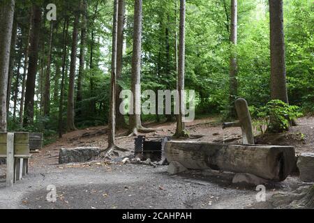 Bequemer und komfortabler Ort mit Zentrum eines Feuers zum Grillen in der Mitte des Waldes mit Quelle von frischem kaltem Trinkwasser ausgeguckt. Stockfoto