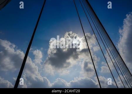 Sonnenstrahlen, die durch Wolken in blauem Himmel über der 2nd Hoogly Bridge, Kalkutta, West Bengal, Indien. Stockfoto