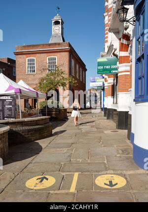 Reigate Surrey High Street - Coronavirus Fußgänger sichere Entfernung & Einbahnrichtung Straßenmarkierungen halten Menschen sicher. Shop Safe Shop Lokal Stockfoto