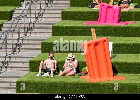 London, Großbritannien. August 2020. Die Menschen sahen die Sonne in Coal Drops Yard neben einem riesigen Eis Lolly genießen, wie die Temperaturen steigen zu, was könnte einer der heißesten Tage auf Rekord in London sein. Kredit: SOPA Images Limited/Alamy Live Nachrichten Stockfoto