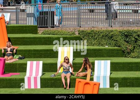 London, Großbritannien. August 2020. Frauen sahen die Sonne in Coal Drops Yard neben einem riesigen Eis Lolly genießen, wie die Temperaturen steigen, was könnte einer der heißesten Tage auf Rekord in London sein. Kredit: SOPA Images Limited/Alamy Live Nachrichten Stockfoto