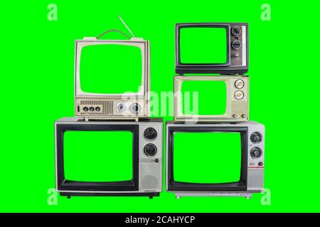 Fünf Vintage-Fernseher auf altem Holztisch mit grünen Bildschirmen und Hintergründen. Stockfoto