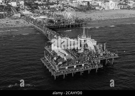 Schwarz-Weiß-Luftaufnahme des überfüllten Santa Monica Pier und Strand in der Nähe von Los Angeles an der Südkalifornien Küste. Stockfoto