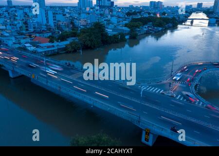 Drohne Aufnahme der Autobahn und Kreuzung über einem Fluss mit Kurven und Streifen von den Scheinwerfern Stockfoto