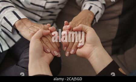Nahaufnahme ältere ältere Frau hält die Hände der erwachsenen Tochter, zeigt Liebe und Fürsorge. Hochwertige 4k-Aufnahmen Stockfoto