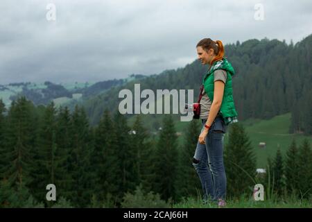 Mädchen Fotografin in den Bergen schießt die Landschaft auf der Hintergrund eines bewölkten Tages Stockfoto