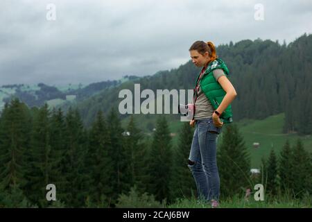 Mädchen Fotografin in den Bergen schießt die Landschaft auf der Hintergrund eines bewölkten Tages Stockfoto