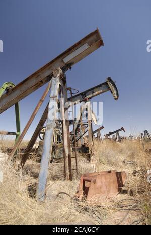 McCamey, Texas, USA, März 2006: Rostende Rümpfe von Ölbrunnenpumpen befinden sich am U.S. Highway 67 im Upton County, wo Windparks Ölbrunnen als neue Wirtschaft Westtexas ersetzen. ©Bob Daemmrich Stockfoto