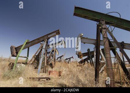 McCamey, Texas, USA, März 2006: Rostende Rümpfe von Ölbrunnenpumpen befinden sich am U.S. Highway 67 im Upton County, wo Windparks Ölbrunnen als neue Wirtschaft Westtexas ersetzen. ©Bob Daemmrich Stockfoto