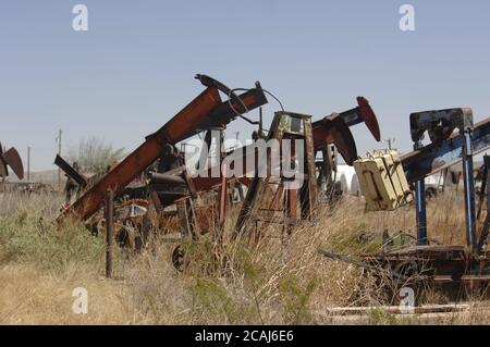 McCamey, Texas, USA, März 2006: Rostende Rümpfe von Ölbrunnenpumpen befinden sich am U.S. Highway 67 im Upton County, wo Windparks Ölbrunnen als neue Wirtschaft Westtexas ersetzen. ©Bob Daemmrich Stockfoto