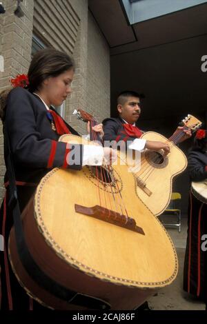 Junge hispanische Männer und Frauen spielen große Bassgitarren in Mariachi-Band während bahnbrechender Zeremonien für die Linder Elementary School in Austin, Texas.©Bob Daemmrich Stockfoto