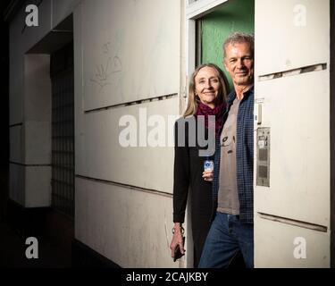 Ein Paar mittleren Alters, das während der COVID-19-Sperre in Stockwell, London, mit einer Flasche Händedesinfektionsmittel in der Tür ihres Hauses stand Stockfoto