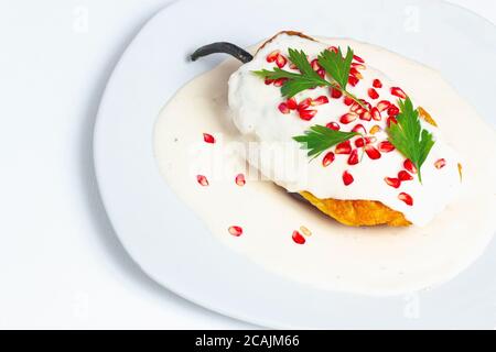 Mexikanische Küche. Chile en nogada auf weißem Hintergrund, minimales Konzept. Mexikanisches Essen Stockfoto