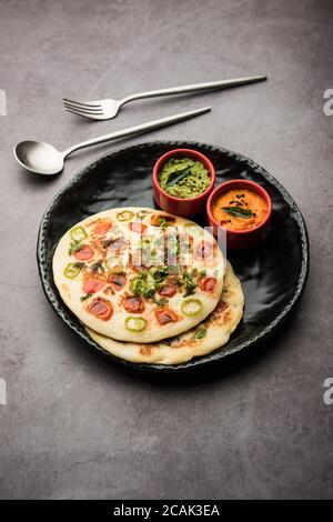 Uthappam oder Utapam ist eine Art Dosa aus Südindien, die dicker ist, mit Tomaten, Zwiebeln und Chili Belag Stockfoto