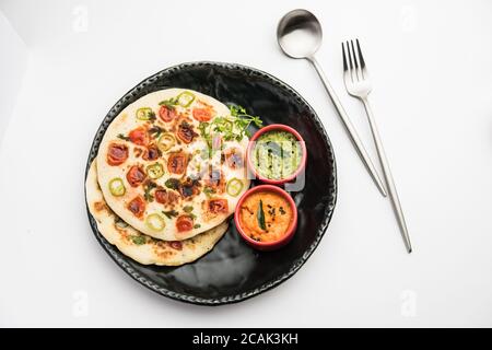 Uthappam oder Utapam ist eine Art Dosa aus Südindien, die dicker ist, mit Tomaten, Zwiebeln und Chili Belag Stockfoto