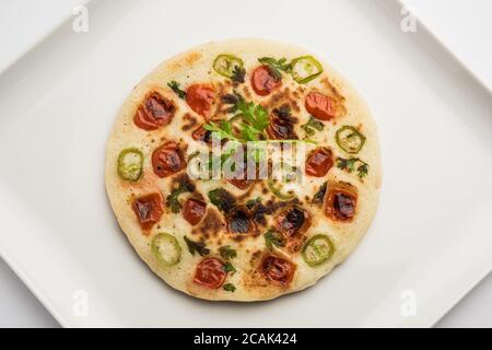 Uthappam oder Utapam ist eine Art Dosa aus Südindien, die dicker ist, mit Tomaten, Zwiebeln und Chili Belag Stockfoto