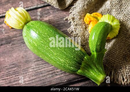 Frisches Gemüse. Hässlich organisch verdrehte Zucchini auf Holztisch. Stockfoto