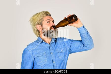 Reifer Mann hält Glasflasche Bier. Betrunkene Hipster männliche Handwerk Flaschenbier. Glücklicher Mann halten volle Glasflasche in der Hand. Männlich hält Flasche Bier. Hipster Rest in Pub. Sportliebhaber Kopf hoch. Stockfoto