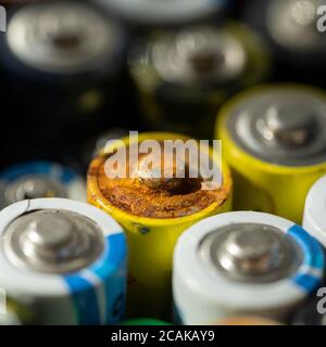 Nahaufnahme von positiven Enden entladener Batterien in verschiedenen Größen und Formaten, selektiver Fokus. Gebrauchte Batterie mit Korrosion und Rost. Gefährliche gar Stockfoto