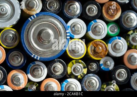 Nahaufnahme von positiven Enden entladener Batterien in verschiedenen Größen und Formaten, selektiver Fokus. Gebrauchte Alkali-Batterie mit Korrosion und Rost. Haza Stockfoto