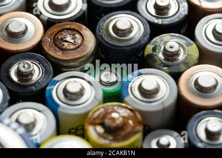 Nahaufnahme von positiven Enden entladener Batterien in verschiedenen Größen und Formaten, selektiver Fokus. Gebrauchte Batterie mit Korrosion und Rost. Gefährliche gar Stockfoto